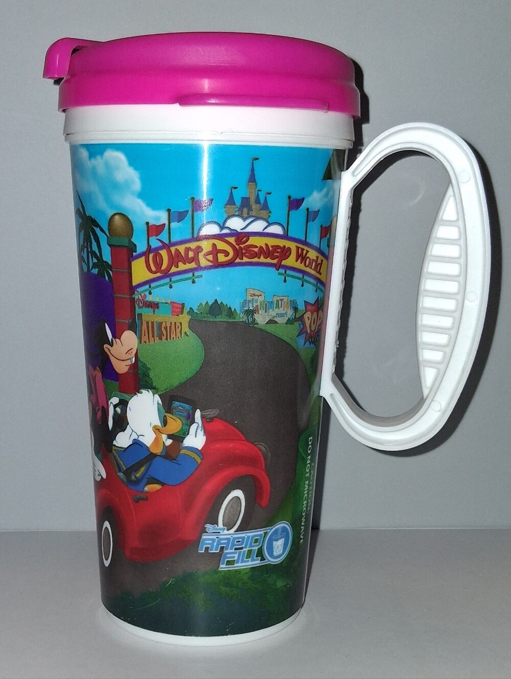 Disney Pink Lid Travel Mug with White Handle and Colorful Disney World Graphics